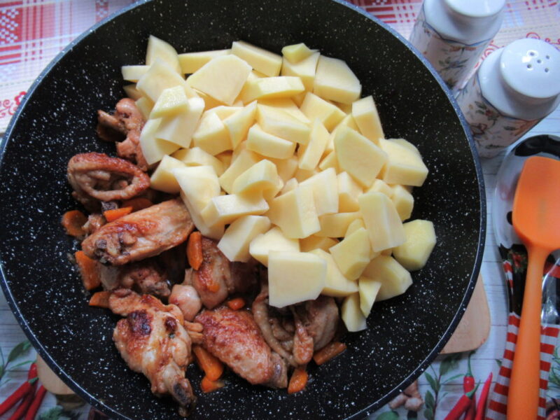 cartofi taiati adaugati la tigaie, acoperiti cu sos