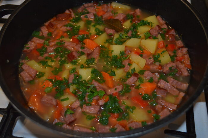 Cartofi scazuti cu salam afumat serviti pe farfurie