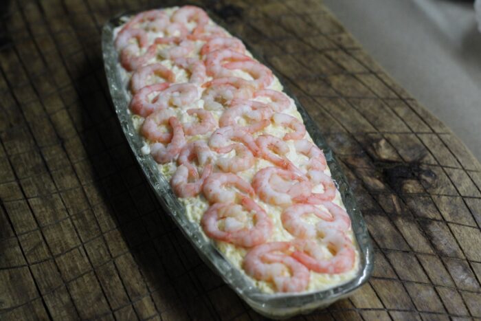 Așezați fructele de mare răcite deasupra salatei