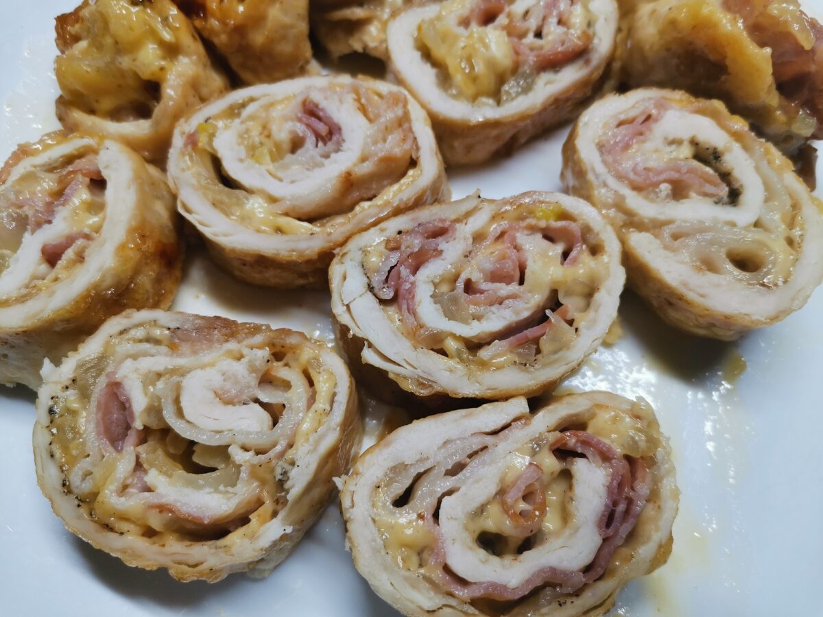 Chicken roll stuffed with cheese, onion and garlic, wrapped in bacon and sliced