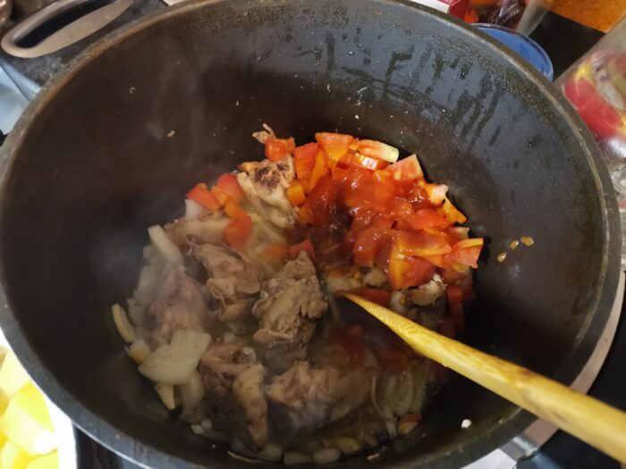 Adăugați roșiile la carne și ceapă