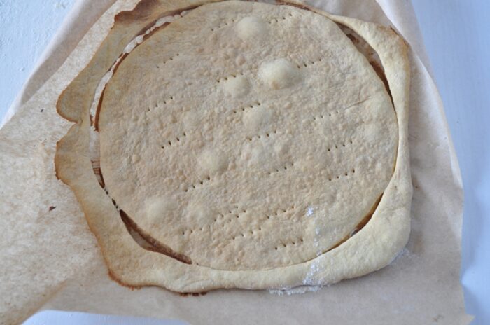 Place the rolled-out dough circle in the oven
