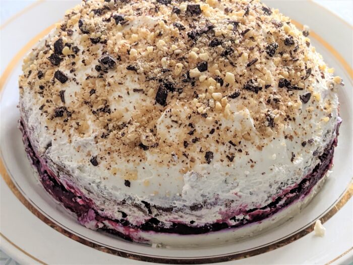 Cover the cake with the remaining cream and sprinkle with walnuts