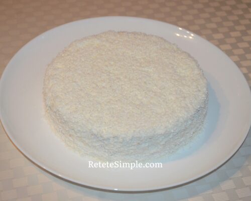 Sprinkle coconut on the surface and sides of the cake