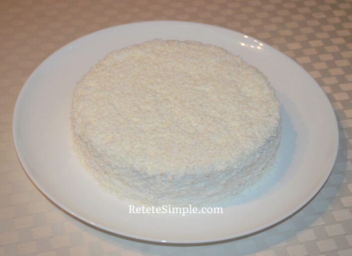 Sprinkle coconut on the surface and sides of the cake