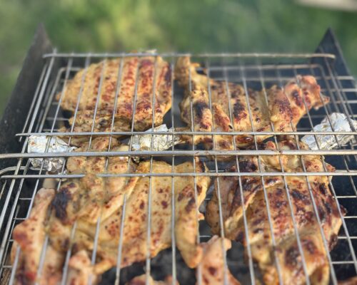 Garlic-marinated chicken thighs sizzling on the grill