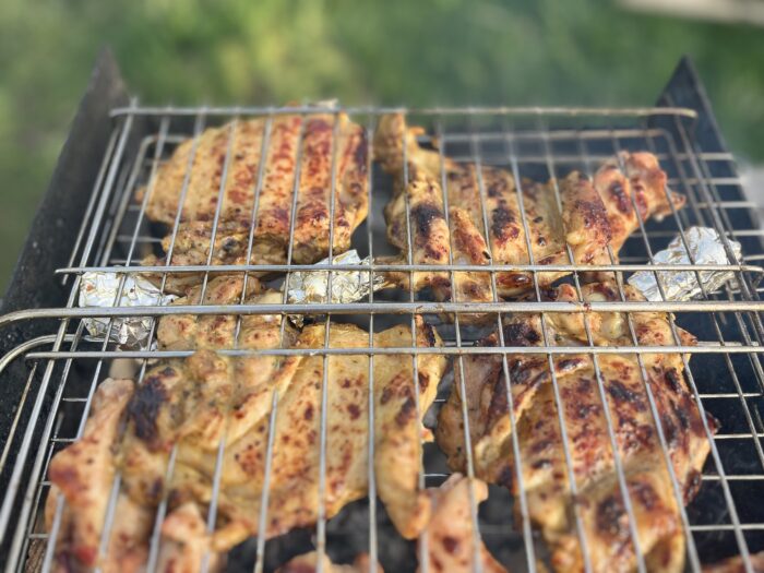 Garlic-marinated chicken thighs sizzling on the grill