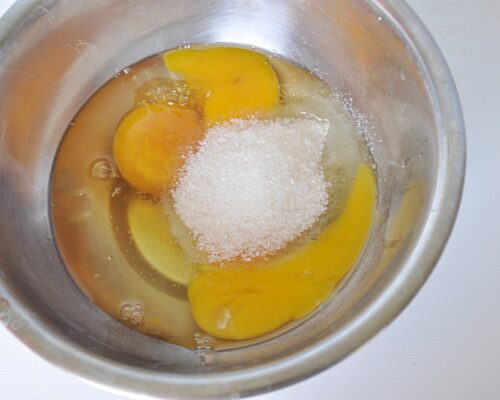 Break the eggs into a large bowl and add sugar to them