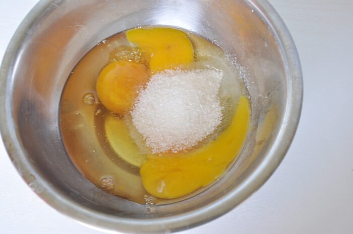 Break the eggs into a large bowl and add sugar to them