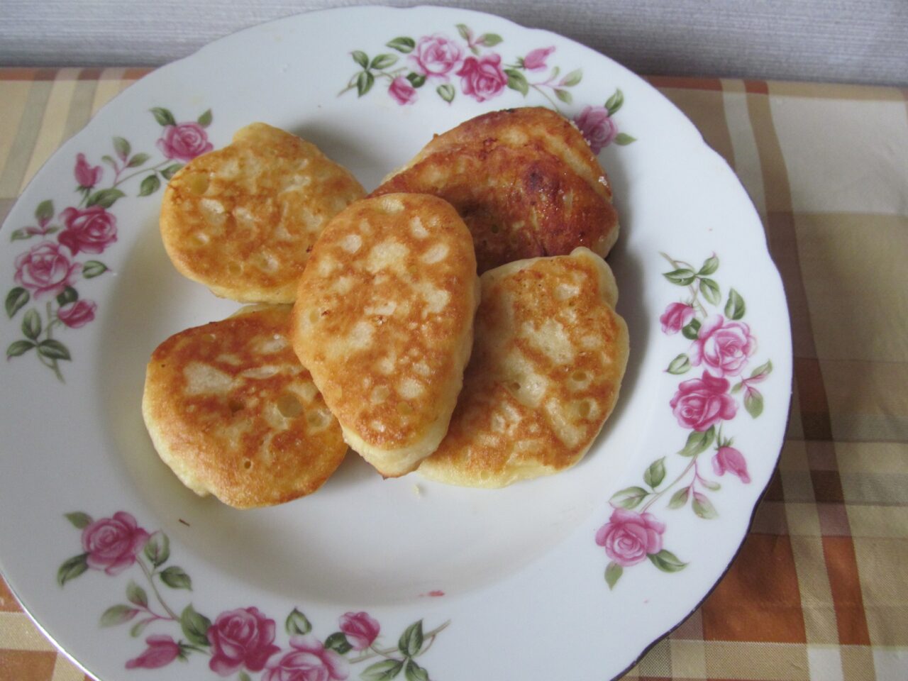 Stack of fluffy kefir pancakes with plum pieces