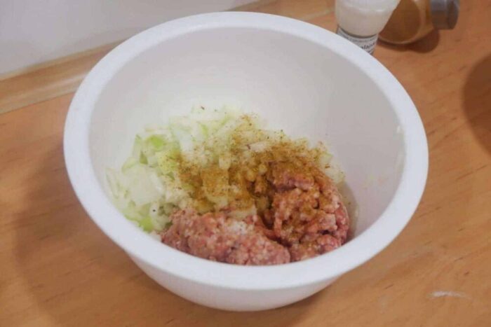 В фарш добавляем измельченный лук, специи, соль