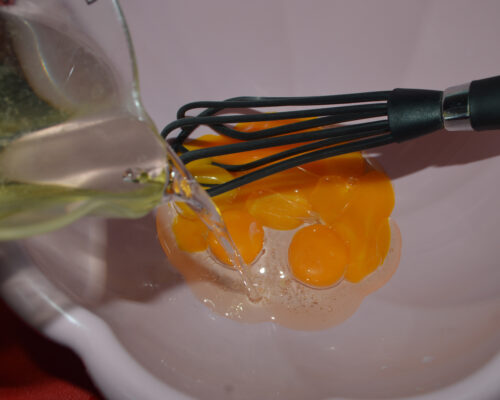 Add oil to egg yolks