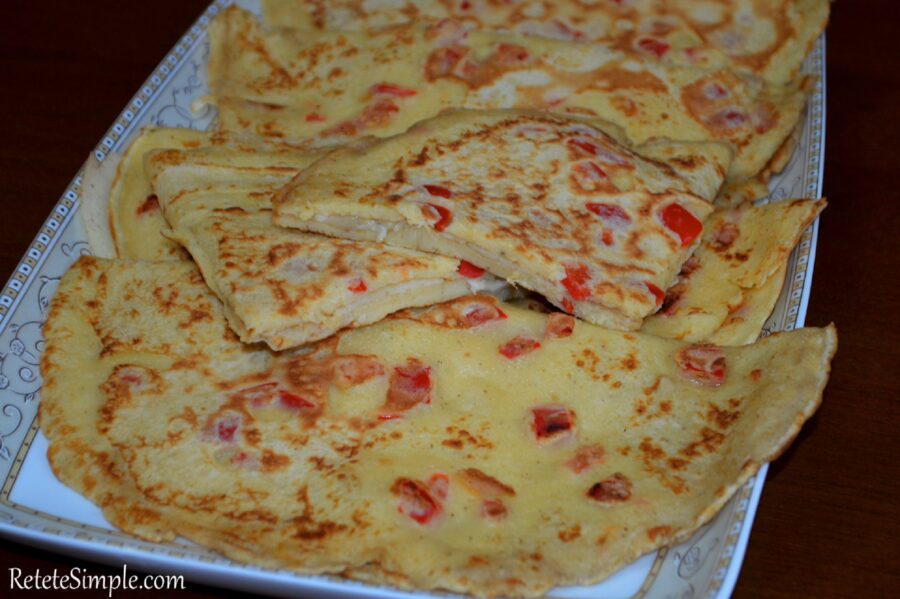 Appetizer pancakes with peppers and cheese sliced on a plate