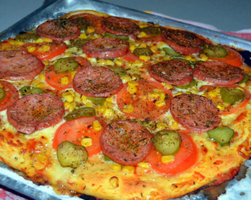 Coaceți pizza cu cârnați pe raftul de sus