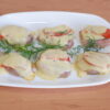 Baked pork medallions topped with tomato and melted cheese
