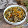 Bowl of hearty chicken gizzards goulash with carrots and onions