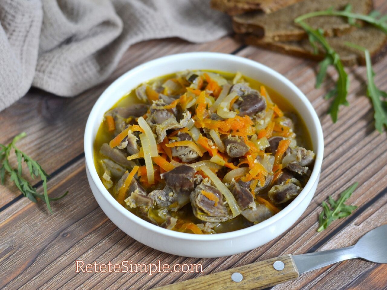 Bowl of hearty chicken gizzards goulash with carrots and onions