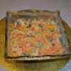 Chicken salad with corn, cucumbers, pickled carrot and cheese in bowl