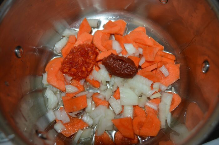 Pour a little oil into a pan and add the onion, carrot