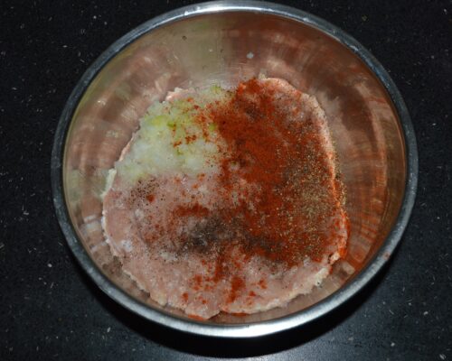 Add the finely grated onion and garlic to the minced chicken