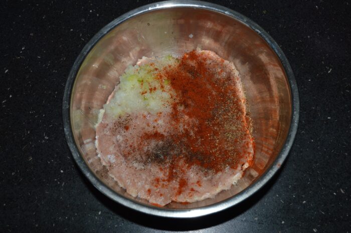 Add the finely grated onion and garlic to the minced chicken