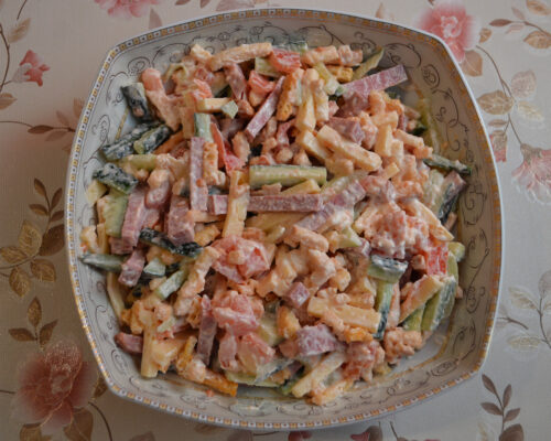 Salad of sliced cucumbers, cheese sticks, croutons and tomato