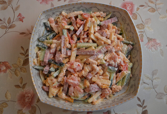 Salad of sliced cucumbers, cheese sticks, croutons and tomato