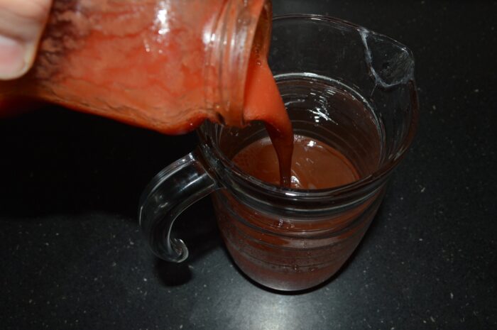 Pour tomato juice into a jug of water