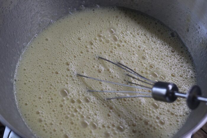 Add the condensed milk and cooled melted butter to the egg