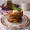 Fluffy kefir pancakes with green onions on a plate
