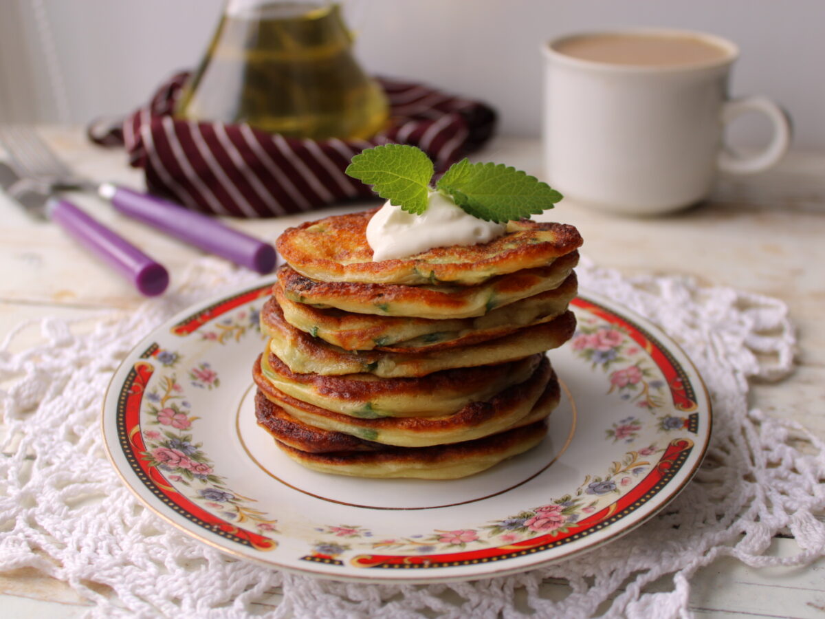 Fluffy kefir pancakes with green onions on a plate