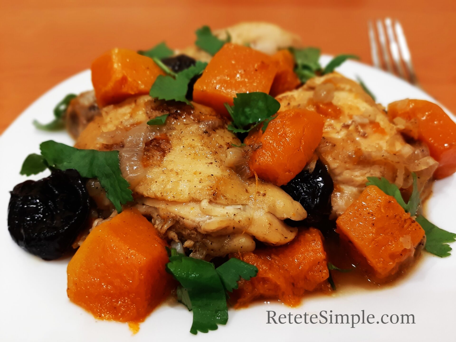 Colorful stew of pumpkin, dried plums and chicken served warm