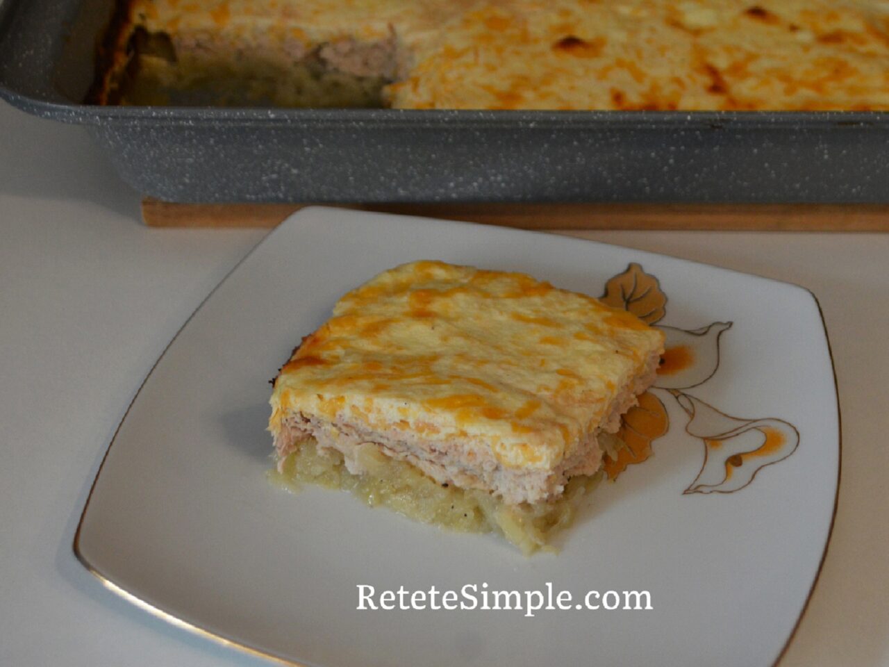 Slice of layered potato, chicken and cheese bake on a plate