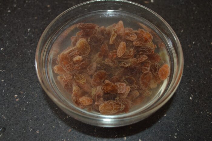 Pour boiling water over the raisins