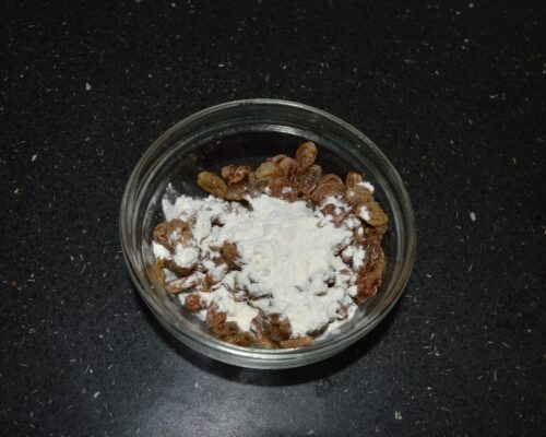 Sprinkle a little flour over the drained raisins