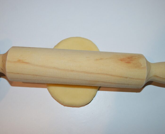 Use a rolling pin to roll out the dough ball a little