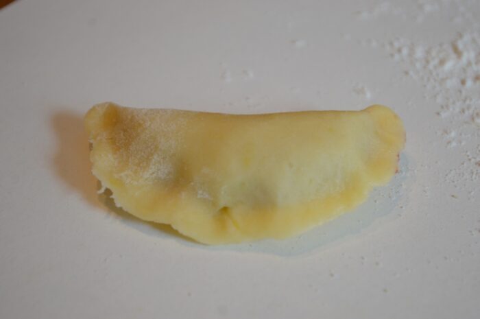 Close the edges of the circle with the filling to form a crescent