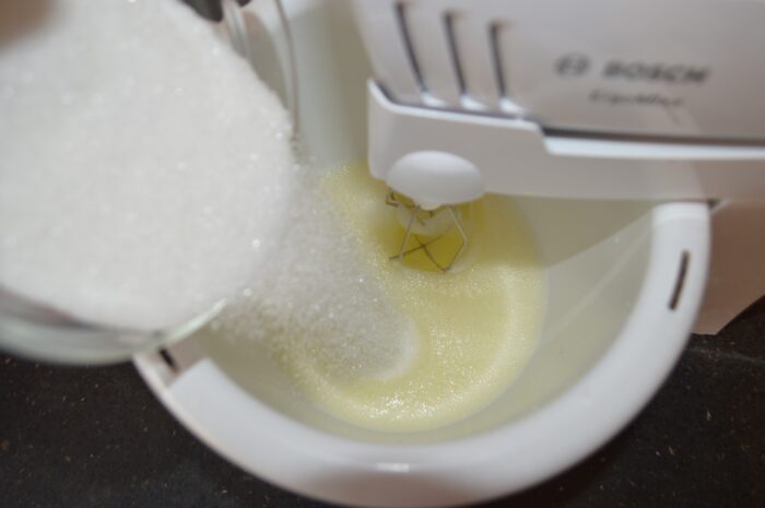 Add 100 g of sugar and vanilla sugar to the egg whites