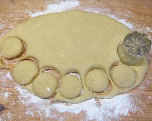 Cut the cookies out of the dough using a cookie cutter