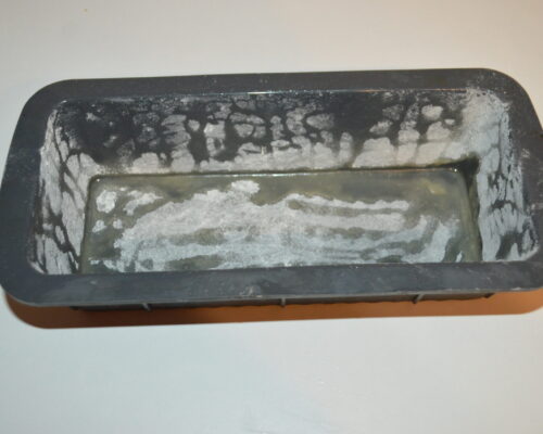 Saupoudrer un peu de farine dans le moule et déplacer