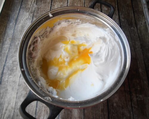 Add the egg yolks while beating