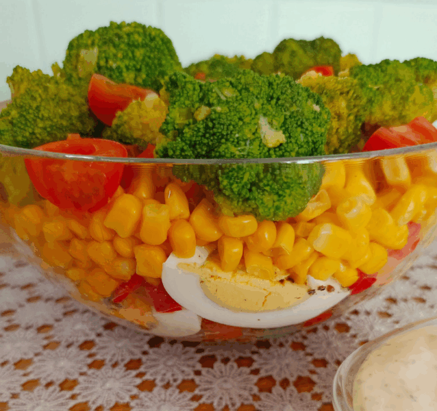 Broccoli and egg salad in glass bowl with cherry tomatoes