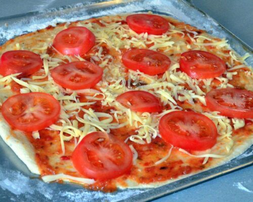 Поверх него – нарезанный кружочками томат