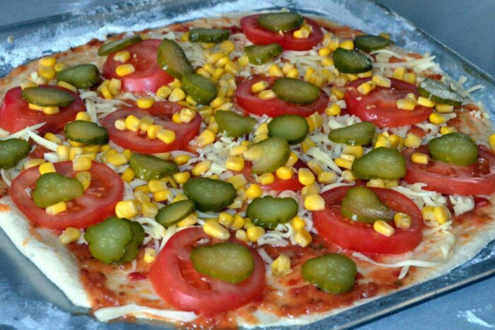 Выложите поперек нарезанные маринованные огурчики