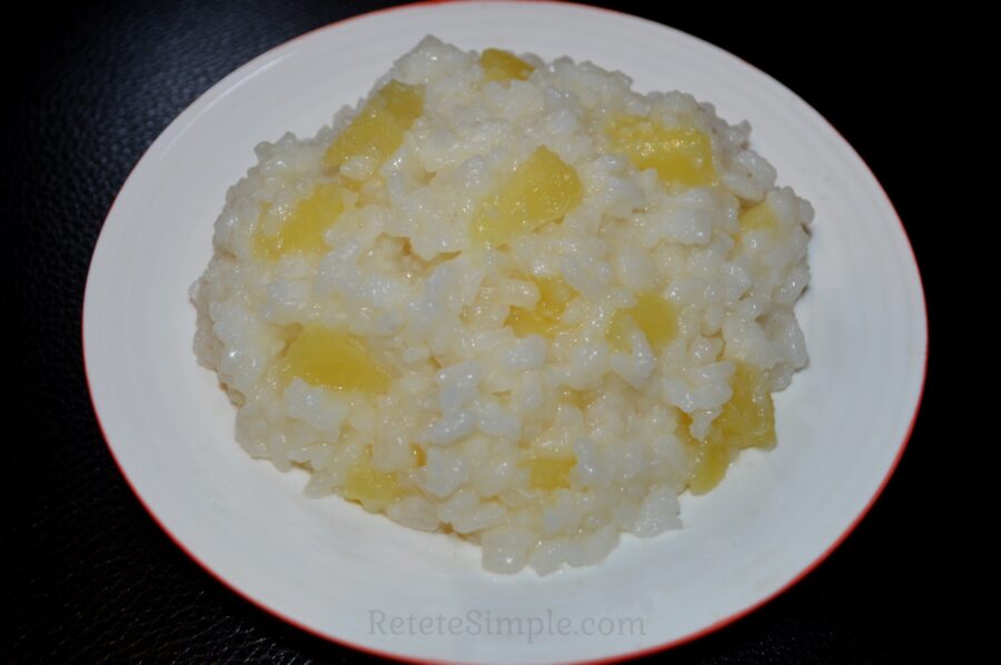 Bowl of sweet rice with apples and cinnamon on wooden table