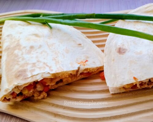 Burrito on wooden board ready to eat with colorful veggies visible