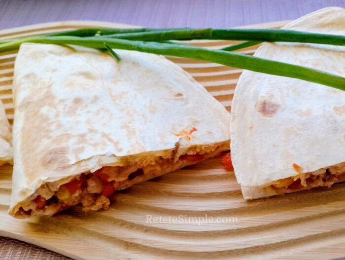 Burrito on wooden board ready to eat with colorful veggies visible