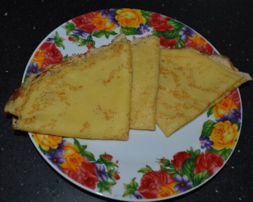 Side view of plate of classic crepes rolled and ready to eat