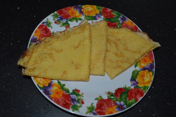 Side view of plate of classic crepes rolled and ready to eat