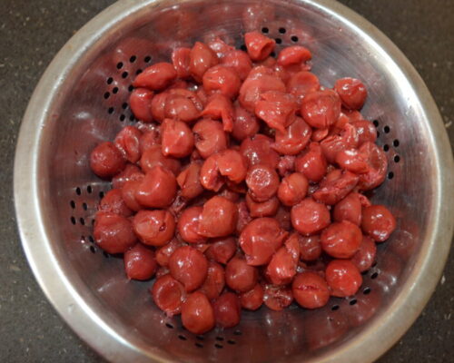 Положите вишни в дуршлаг